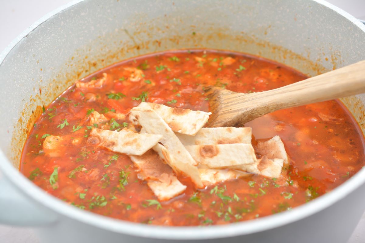 Chicken and tortilla soup in a pot.