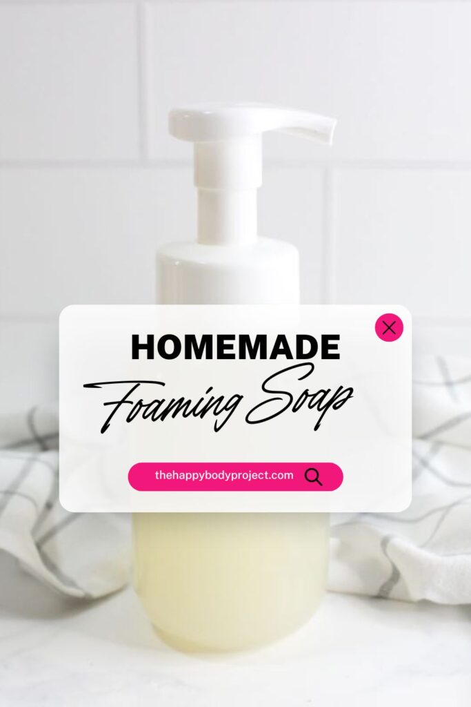 A foaming soap dispenser filled with a light-colored liquid is set against a white, tiled background. A text overlay reads "Homemade Foaming Soap" with a website link at the bottom. A cloth is draped behind the dispenser.