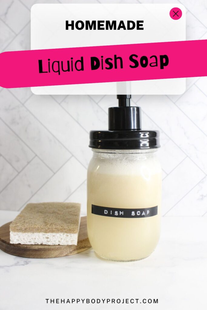 A mason jar filled with homemade liquid dish soap labeled "Dish Soap" is on a countertop. A sponge sits beside the jar. The text "Homemade Liquid Dish Soap" is displayed above. The background is a tiled wall.