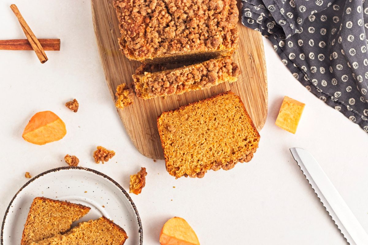 A loaf of sweet potato bread on a cutting board.