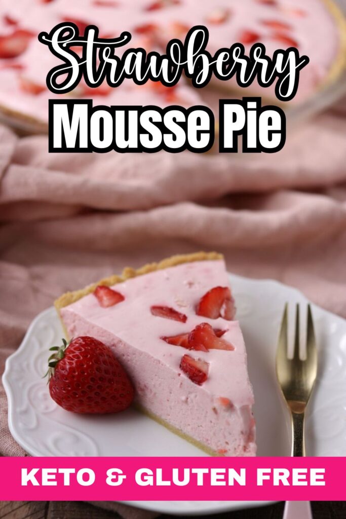 A slice of strawberry mousse pie on a white plate, topped with strawberry pieces. A whole strawberry is beside the slice. The text reads "Strawberry Mousse Pie" and "Keto & Gluten Free." A pink cloth and fork are in the background.