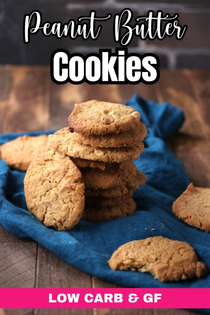 Gluten Free Peanut Butter Cookies A stack of peanut butter cookies sits on a blue cloth atop a rustic wooden surface, with several cookies scattered around. Text reads "Peanut Butter Cookies" and "Low Carb & GF" in bold white and pink lettering.